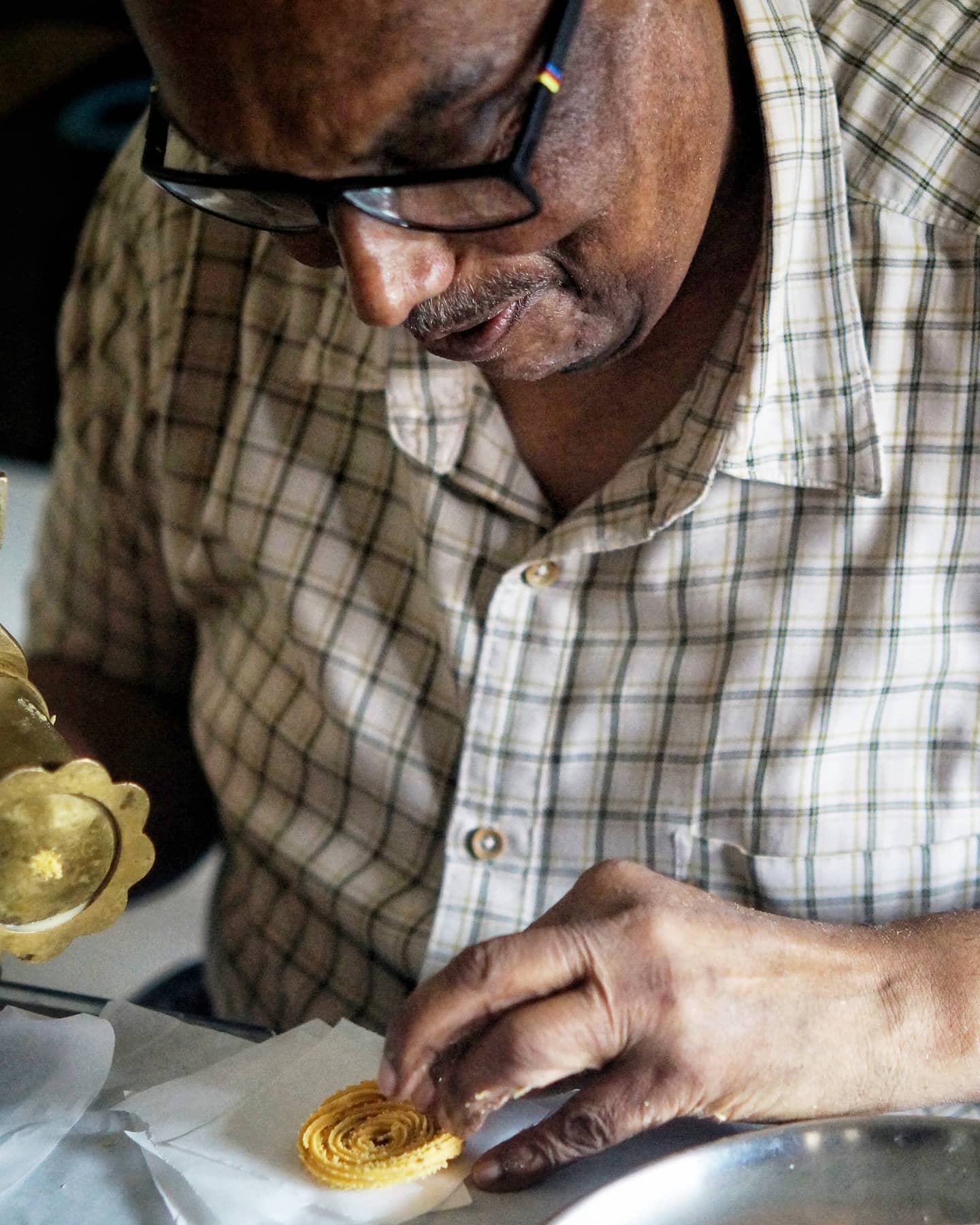 Pappa shaping a chakuli spiral on a paper square