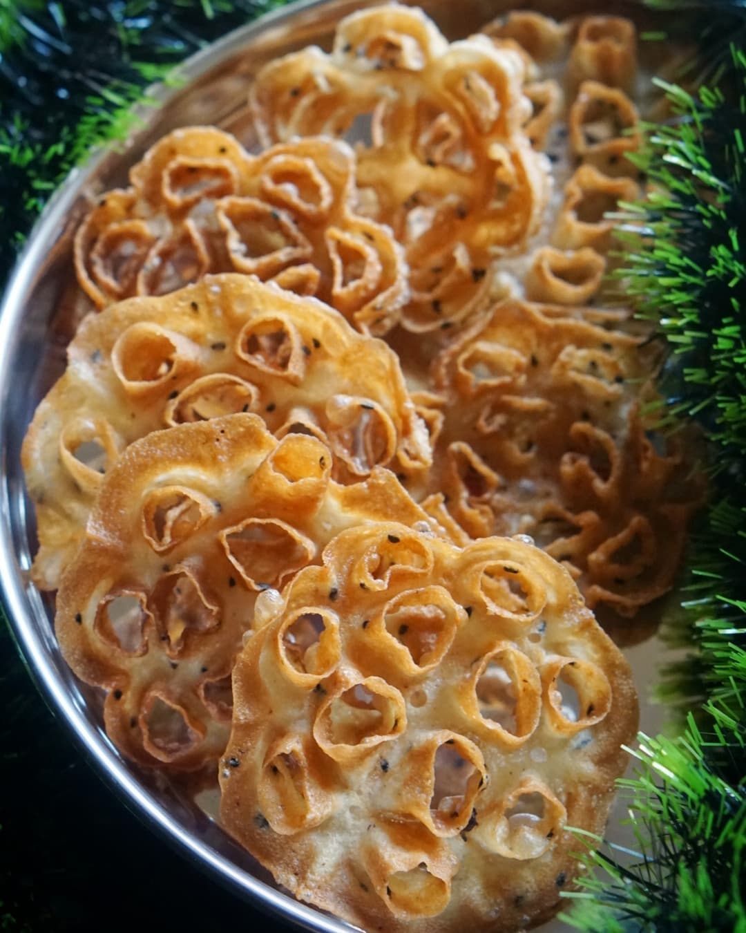 Golden Kokkisan rose cookies on a steel platter