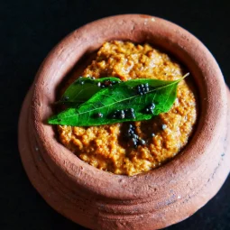 Kuddu tha chutney with curry leaves and mustard seeds in a clay bowl