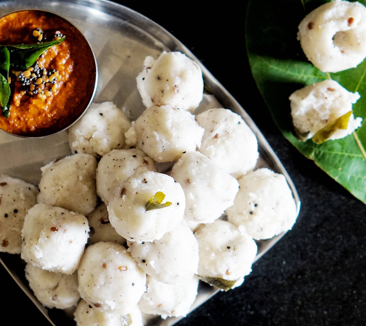 Steamed Nesal Pundi rice balls served with a red chutney