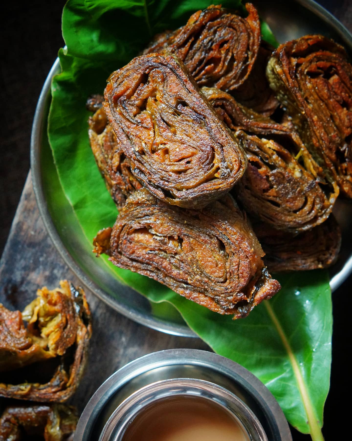 Pan-fried Pathrode slices showing layers of colocasia leaves and spiced paste
