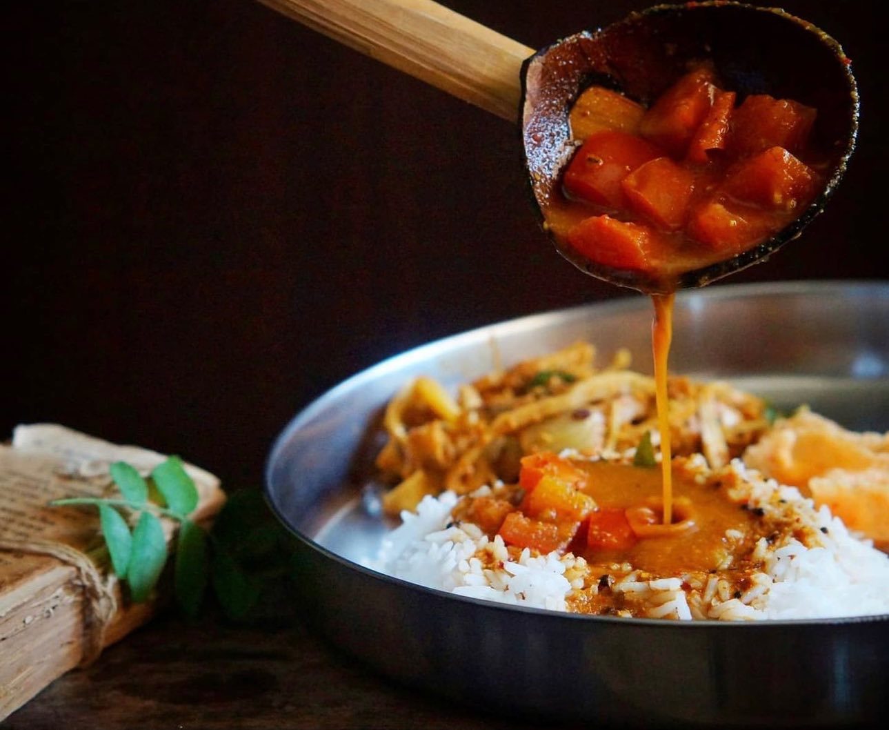 Temple-style saar poured over rice from a ladle